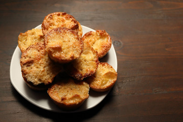 White dish with muffins on a wooden background.