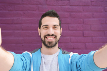 Happy young man taking a selfie.