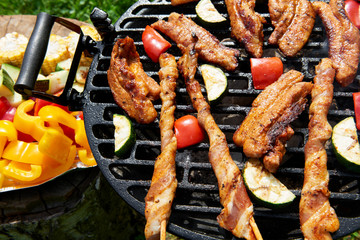 Meat and vegetables during grilling. Assorted types of bacon