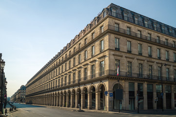 Obraz premium A typical Haussmann style building in Paris with balconies, arches and shops under a warm light of late afternoon.