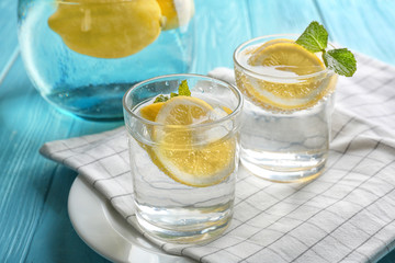 Composition with cold lemon water on wooden table, closeup