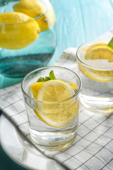 Composition with cold lemon water on wooden table, closeup