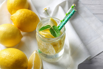 Composition with cold lemon water on wooden table, closeup