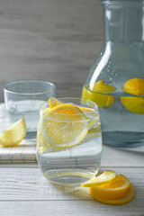 Composition with cold lemon water on wooden table