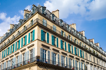 Fototapeta na wymiar A typical Haussmannian building in Paris with balconies and shutters under a warm light of late afternoon.