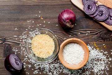 paella ingredients with rice, salt, spices and tomatoes on wooden table background top view