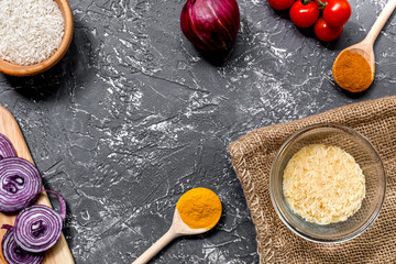 cooking paella with vegetables and rice on dark desk background top view mockup