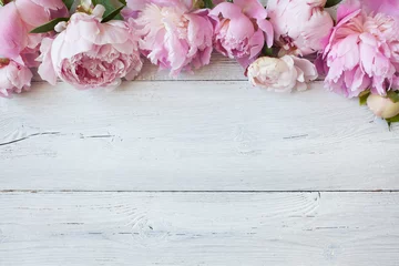 Rolgordijnen Pink flowers peonies on a white wooden background, space for text greeting © tachinskamarina