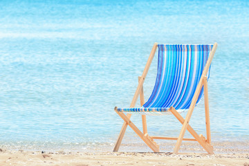 Comfortable beach chair at sea shore. Vacation concept