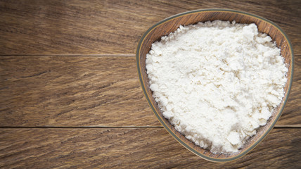 Fototapeta na wymiar Wheat flour in wooden bowl