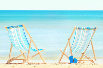 Pair of beach chairs at sea shore. Vacation concept
