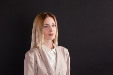 Young woman in a business suit on a black background