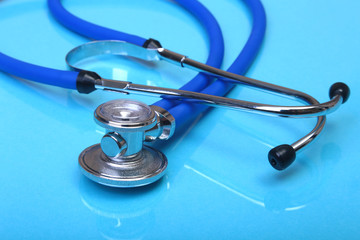 medical stethoscope and red heart on blue mirror background. selective focus.