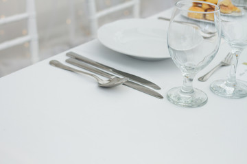 table setting with spoon, knife, plates and glass