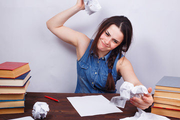 Student girl crumpling sheets of paper. Young stressed furious woman tearing paper. Stress, fatigue, routine, dismissal concept