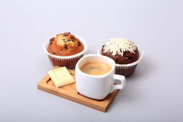 Classic espresso in white cup with homemade cake and chocolate on white background.