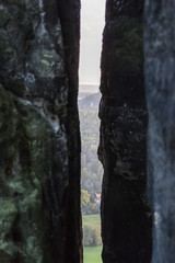 A narrow dark long gap between two stony cliffs