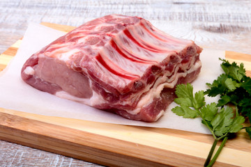 Fototapeta premium Raw pork chops, spices and basil on cutting board. Ready for cooking.