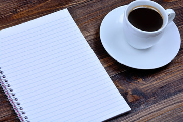 Notebook with coffee on table