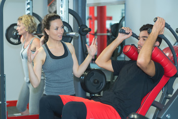 Fototapeta premium fit man trening na maszynie prasowej w gymclub