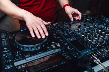 Music from vinyl. Hands DJ mixing music at the club during the event