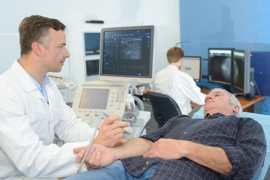 male doctor with male patient undergoing arm echography