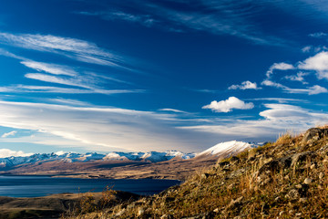 view of the mountains, lake and valey in a sunny day from mount john/ lake tekapo