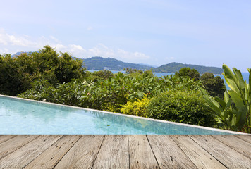 wooden floor with swimming pool overlooking view andaman sea mountains and blue sky background,summer holiday background concept.