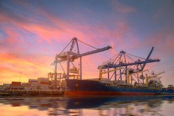 Fototapeta na wymiar Logistics and transportation of Container Cargo ship and Cargo plane with working crane bridge in shipyard at Twilight sky, logistic import export background and transport industry.