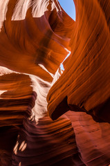Orange peach wave shapes photographed at slots canyons in Arizona with blue sky
