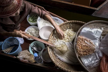 Fotobehang old woman making thai noodle food by sailing in local floating boat market © stockphoto mania