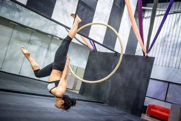 young asian acrobatic woman doing her gymnastics performance on aerial hoop or aerial ring © zephyr_p