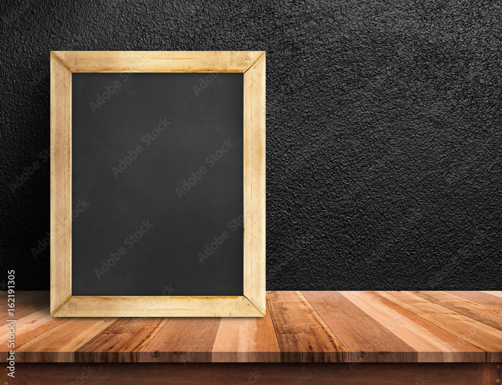 Fototapete Blank blackboard on wood plnak table at black concrete wall,Template mock up for adding your design and leave space beside frame for adding more text