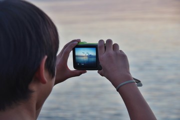 夕焼けを撮影する少年