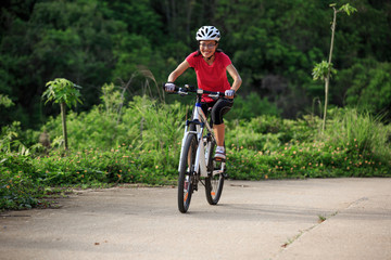 Obraz na płótnie Canvas woman cyclist cycling on summer forest trail