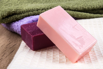 natural soap bar with bath towel on wooden background