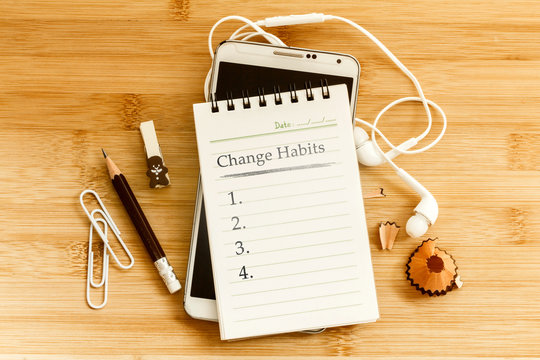Hand written  Change habits message notepad with the  pencil  on wooden table for change habits  list for good life concept , overhead shot or Top view