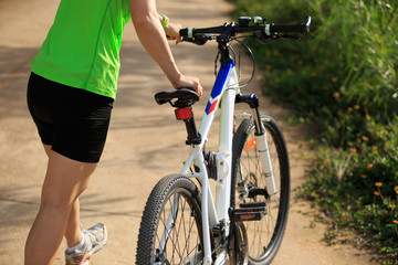 Obraz premium woman cyclist cycling on summer forest trail