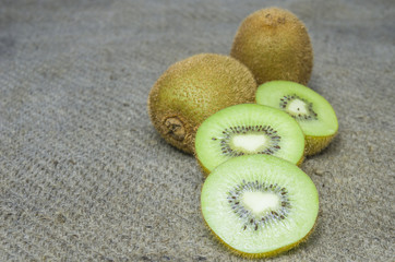 Ripe whole kiwi fruit and half kiwi fruit isolated put on brown sack