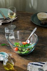 Bowl of fresh salad on kitchen wooden table