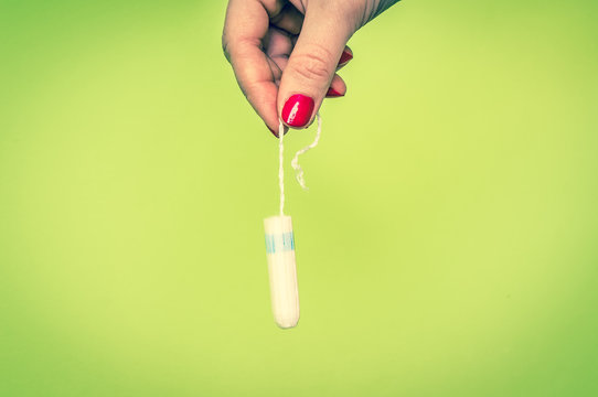 Woman holding menstruation tampon in hand