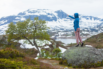 Tourist woman enjoying mountains landscape in Norway