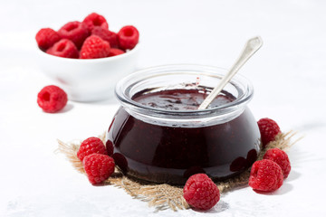 raspberry jam in a glass jar on white background