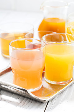 fresh citrus juices in assortment, vertical closeup