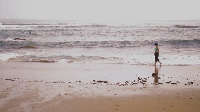 femme triste marche sur la plage