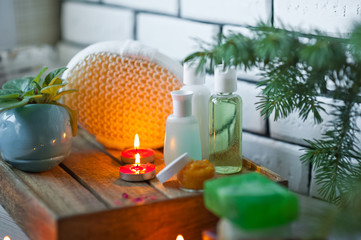 Bathroom accessories. Body care. Multi-colored natural soap, gels, shampoos, balms in vials, sea salt for a bath, a bast. Bathroom cosmetics on a light, white background. Spa treatments with candles