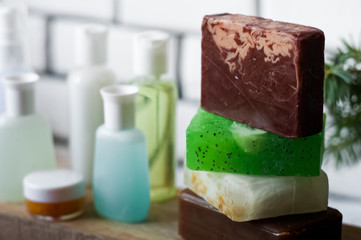 Bathroom accessories. Body care. Multi-colored natural soap, gels, shampoos, balms in vials, sea salt for a bath, a bast. Bathroom cosmetics on a light, white background. Spa treatments with candles