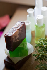 Bathroom accessories. Body care. Multi-colored natural soap, gels, shampoos, balms in vials, sea salt for a bath, a bast. Bathroom cosmetics on a light, white background. Spa treatments with candles