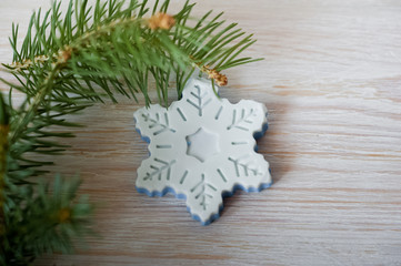 Bathroom accessories. Body care. Natural cosmetic soap in the form of a snowflake and a twig of a Christmas tree. Cosmetic piece of soap on a light white background with pine needles. Spa treatments