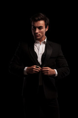 Obraz premium elegant man unbuttoning his suit and looks to side